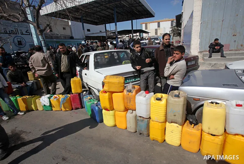 Palestinians wait to fill containers with fuel at a petrol station in Gaza City March 26, 2012. Palestinians in the Gaza Strip are suffering a crisis of dry petrol pumps and frequent blackouts triggered by a fuel supply...