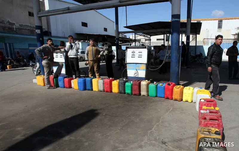 Palestinians wait to fill containers with fuel at a petrol station in Gaza City March 26, 2012. Palestinians in the Gaza Strip are suffering a crisis of dry petrol pumps and frequent blackouts triggered by a fuel supply...