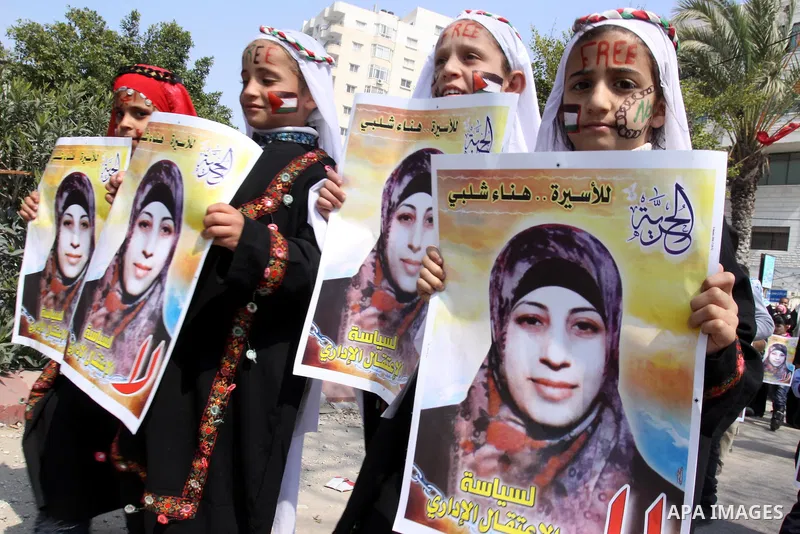 Palestinian children hold portrait of jailed compatriot Hana Shalabi, a female Palestinian prisoner jailed in Israel, outside the Red Cross building in Gaza City on March 27, 2012. Photo by Mohammed Asad