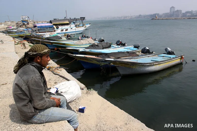 A Palestinian fisherman sits in the port of Gaza city on March 28, 2012, after his boat stopped working due to lack of fuel. Gaza is experiencing a major electricity crisis because of a shortage of fuel for the power pla...