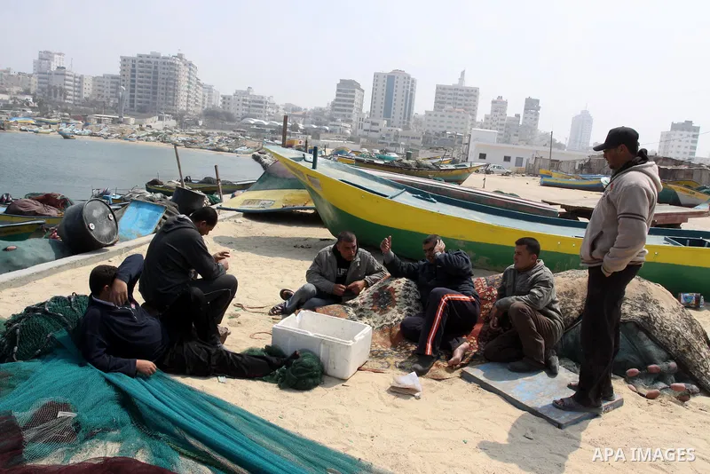 Palestinian fishermen sit in the port of Gaza city on March 28, 2012, after his boat stopped working due to lack of fuel. Gaza is experiencing a major electricity crisis because of a shortage of fuel for the power plant....