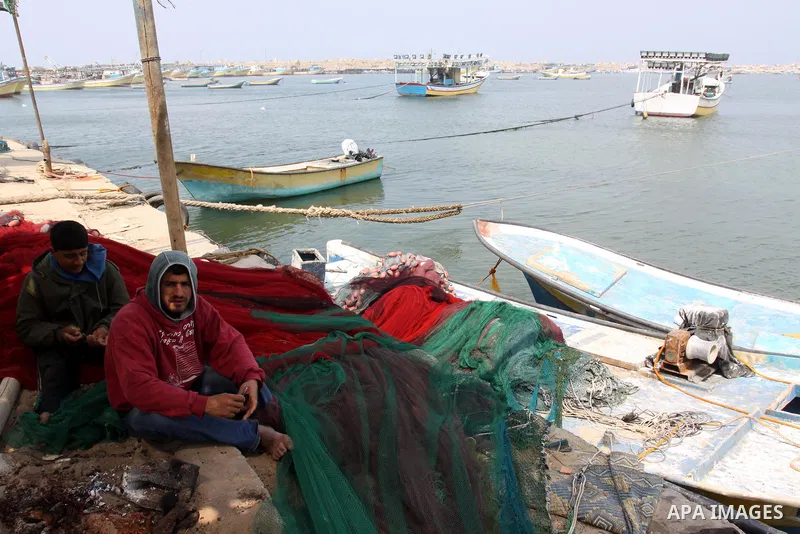 Palestinian fishermen sit in the port of Gaza city on March 28, 2012, after his boat stopped working due to lack of fuel. Gaza is experiencing a major electricity crisis because of a shortage of fuel for the power plant....