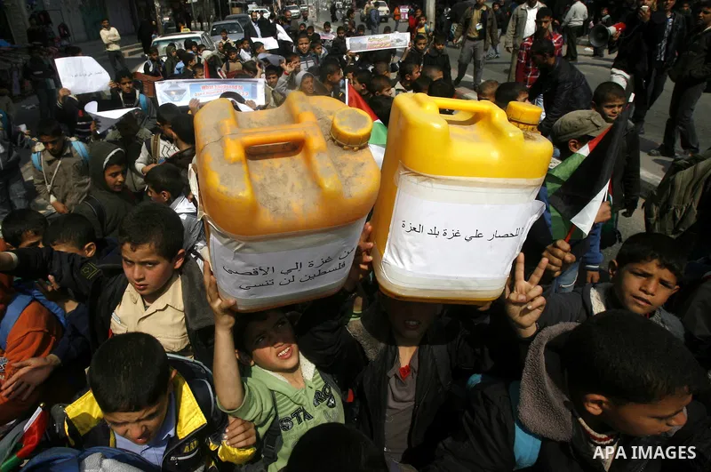 Palestinian children hold logos during protest in Rafah on the southern Gaza Strip on, 28 March 2012 . Gaza is experiencing a major electricity crisis because of a shortage of fuel for the power plant. Photo by Eyad Al B...