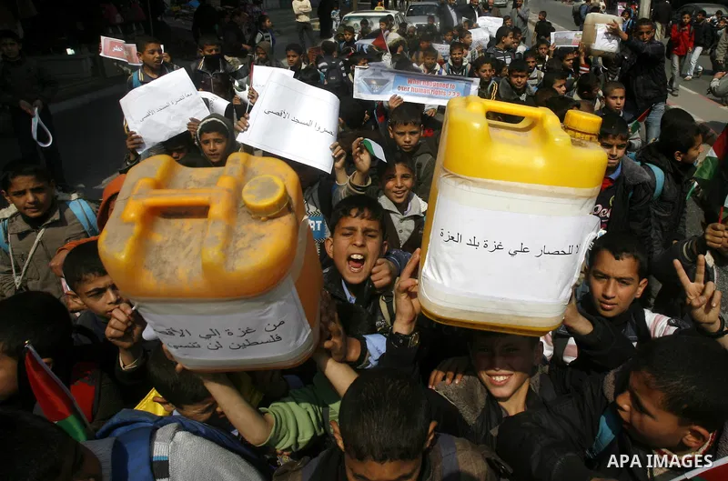 Palestinian children hold logos during protest in Rafah on the southern Gaza Strip on, 28 March 2012 . Gaza is experiencing a major electricity crisis because of a shortage of fuel for the power plant. Photo by Eyad Al B...