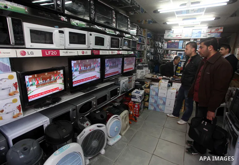 Palestinians watch TV. during a meeting of Arab foreign ministers in the framework of the Arab summit in Baghdad, Iraq, March 29, 2012. Photo by Ashraf Amra