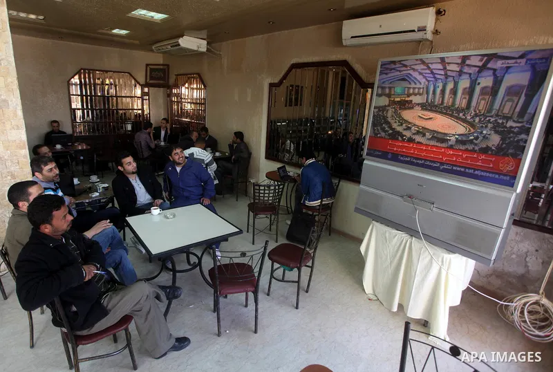 Palestinians watch TV. during a meeting of Arab foreign ministers in the framework of the Arab summit in Baghdad, Iraq, March 29, 2012. Photo by Ashraf Amra