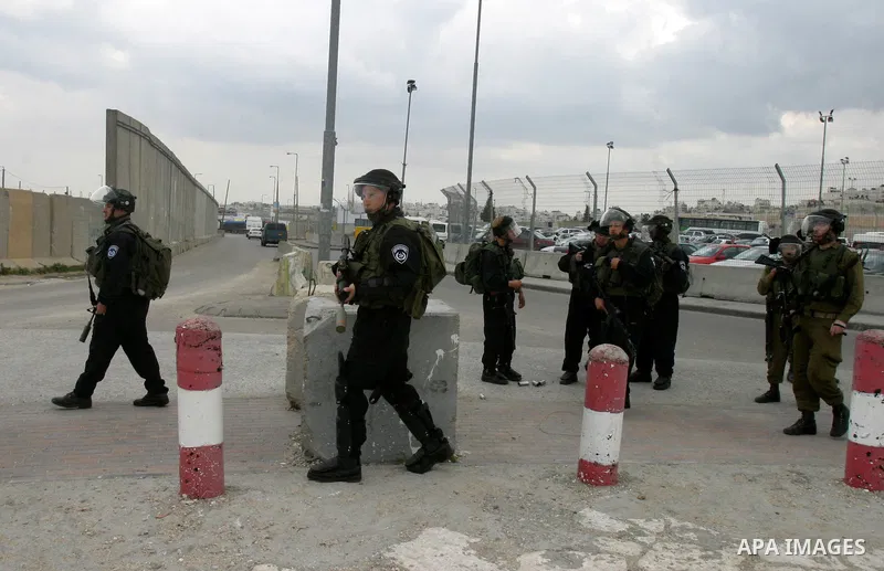 Israeli soldiers take position during clashes with Palestinian youths at the Qalandia checkpoint between the West Bank city of Ramallah and Jerusalem, on 29 March 2012. Photo by Mahfouz Abu Turk