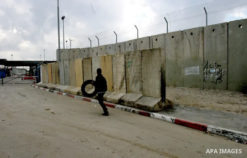 A Palestinian boy throw stones towards Israeli soldiers during clashes at the Qalandia checkpoint between the West Bank city of Ramallah and Jerusalem, on 29 March 2012. Photo by Mahfouz Abu Turk