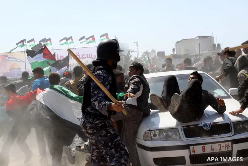 A member of Hamas security forces prevents Palestinian protesters from reaching the border between Israel and the northern Gaza Strip, after a protest marking Land Day March 30, 2012. Israeli security forces fired rubber...