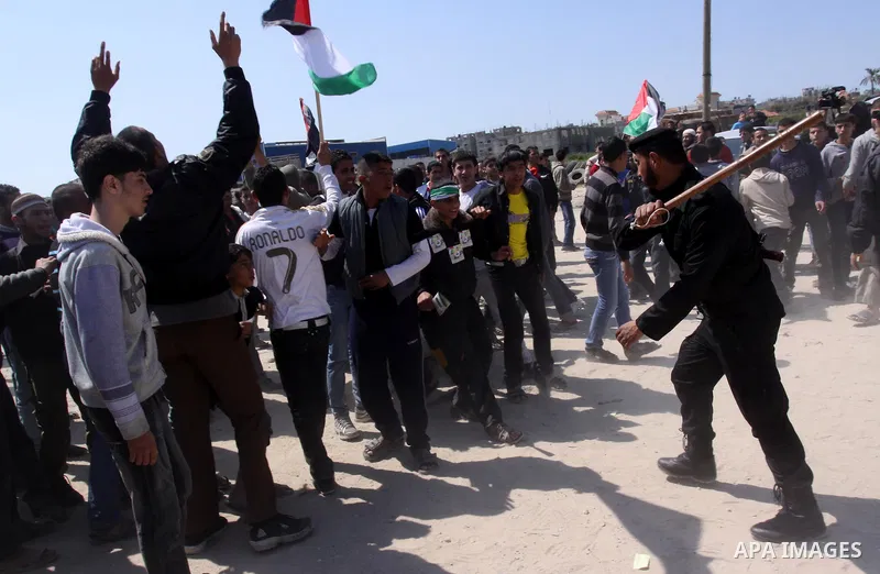 A member of Hamas security forces prevents Palestinian protesters from reaching the border between Israel and the northern Gaza Strip, after a protest marking Land Day March 30, 2012. Israeli security forces fired rubber...