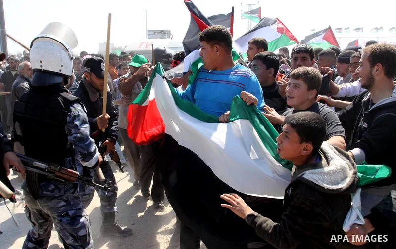 Members of Hamas security forces prevent Palestinian protesters from reaching the border between Israel and the northern Gaza Strip, after a protest marking Land Day March 30, 2012. Israeli security forces fired rubber b...