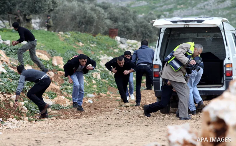 Palestinian protesters and journalists run to take cover from tear gas canisters fired by Israeli soldiers during a demonstration to mark the anniversary of Land Day in the village Iraq Burin, near town of Nablus in the...