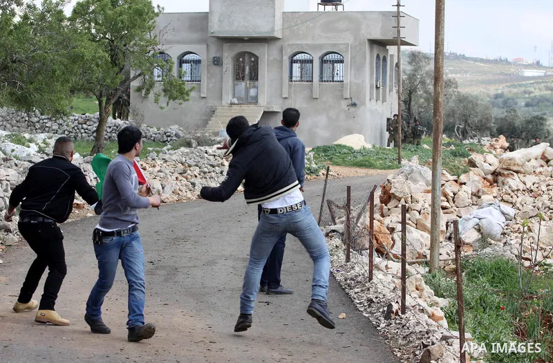 Palestinian protesters throw stones at Israeli soldiers during a demonstration to mark the anniversary of Land Day in the village Iraq Burin, near town of Nablus in the occupied Israeli West bank on March 30, 2012. Land...