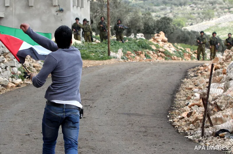 A Palestinian protester throws stones at Israeli soldiers during a demonstration to mark the anniversary of Land Day in the village Iraq Burin, near town of Nablus in the occupied Israeli West bank on March 30, 2012. Lan...