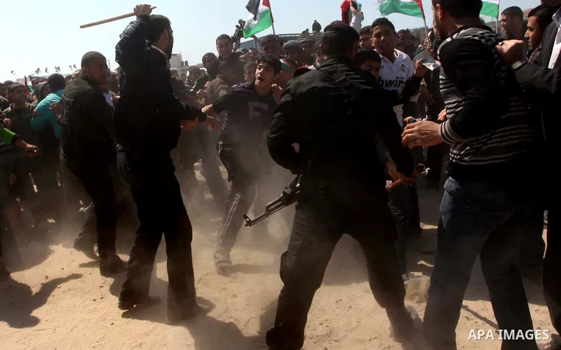 Members of Hamas security forces prevent Palestinian protesters from reaching the border between Israel and the northern Gaza Strip, after a protest marking Land Day March 30, 2012. Israeli security forces fired rubber b...