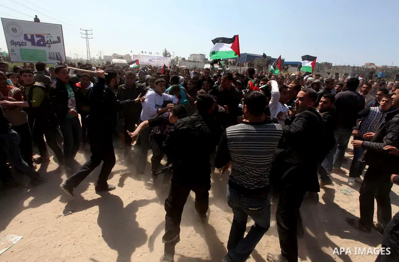 Members of Hamas security forces prevent Palestinian protesters from reaching the border between Israel and the northern Gaza Strip, after a protest marking Land Day March 30, 2012. Israeli security forces fired rubber b...