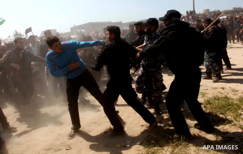 Members of Hamas security forces prevent Palestinian protesters from reaching the border between Israel and the northern Gaza Strip, after a protest marking Land Day March 30, 2012. Israeli security forces fired rubber b...