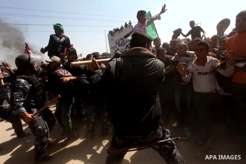 Members of Hamas security forces prevent Palestinian protesters from reaching the border between Israel and the northern Gaza Strip, after a protest marking Land Day March 30, 2012. Israeli security forces fired rubber b...