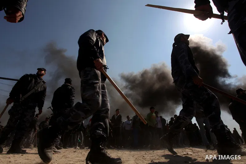 Members of Hamas security forces prevent Palestinian protesters from reaching the border between Israel and the northern Gaza Strip, after a protest marking Land Day March 30, 2012. Israeli security forces fired rubber b...