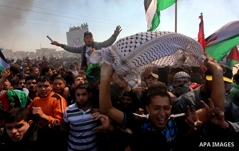 Palestinian protesters shout during a protest marking Land Day, near the border between Israel and the northern Gaza Strip March 30, 2012. Israeli security forces fired rubber bullets, tear gas and stun grenades to break...