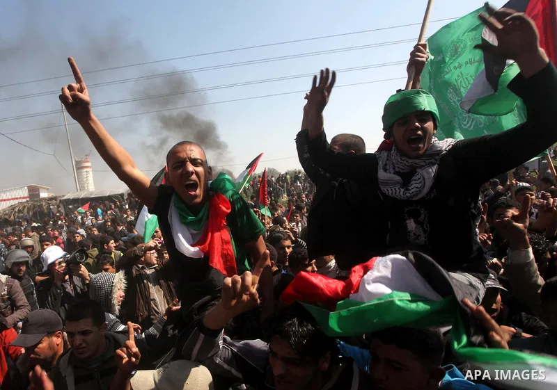 Palestinian protesters shout during a protest marking Land Day, near the border between Israel and the northern Gaza Strip March 30, 2012. Israeli security forces fired rubber bullets, tear gas and stun grenades to break...