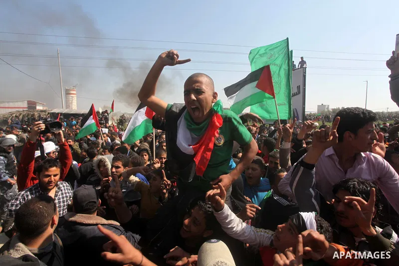 Palestinian protesters shout during a protest marking Land Day, near the border between Israel and the northern Gaza Strip March 30, 2012. Israeli security forces fired rubber bullets, tear gas and stun grenades to break...