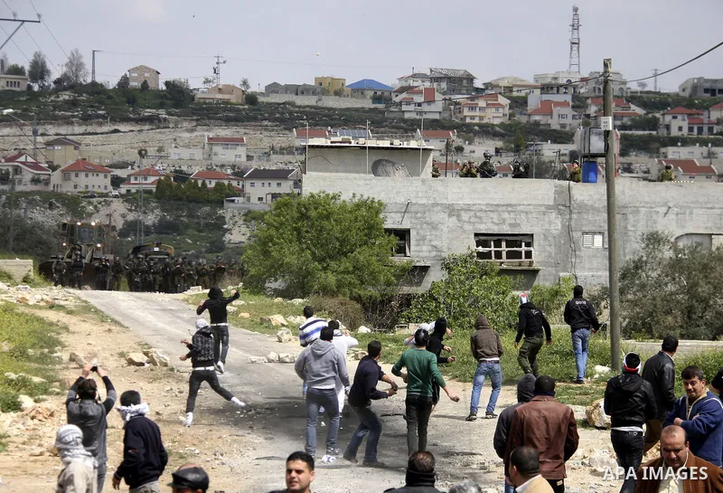 Palestinian protesters throw stones at Israeli soldiers during a demonstration to mark the anniversary of Land Day in the village Kafr Qaddum, close to the northern town of Nablus in the occupied Israeli West bank on Mar...