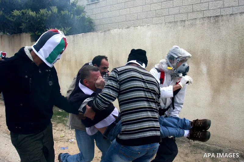 Palestinians carry an injured protester during clashes between Palestinian protesters and Israeli soldiers following a demonstration to mark the anniversary of Land Day in the village Kafr Qaddum, close to the northern t...