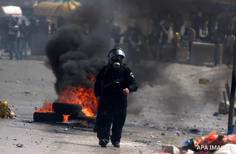 Israeli police officers fire rubber bullets at Palestinians protesters as clashes errupted during the commemoration of Land Day in Qalandia which lies between Jerusalem and the West Bank city of Ramallah on March 30, 201...