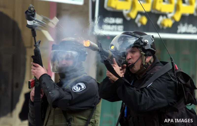 Israeli troops fire teargas at protesters during clashes at Kalandia checkpoint between Jerusalem and the West Bank city of Ramallah, Friday, March 30, 2012. Israeli security forces in riot gear Friday confronted Palesti...