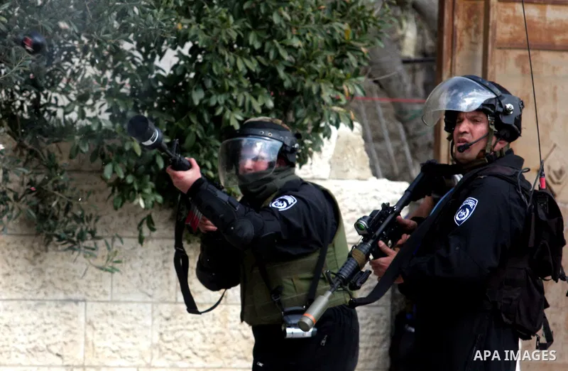 Israeli troops fire teargas at protesters during clashes at Kalandia checkpoint between Jerusalem and the West Bank city of Ramallah, Friday, March 30, 2012. Israeli security forces in riot gear Friday confronted Palesti...