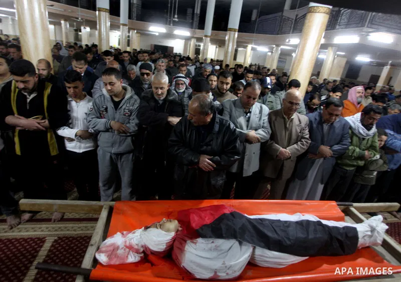 Palestinian mourners pray next to the body of Mahmoud Zakot, 20, during his funeral in the northern Gaza Strip March 30, 2012. Israeli security forces shot dead Zakot in the Gaza Strip on Friday, medics said, and clashed...