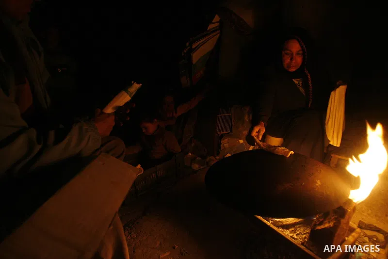 Palestinians prepare freshly baked pita bread at a traditional bakery using a wood burning stove in the Rafah refugee camp in the southern Gaza Strip on March 31, 2012. Gaza is experiencing a major electricity crisis bec...