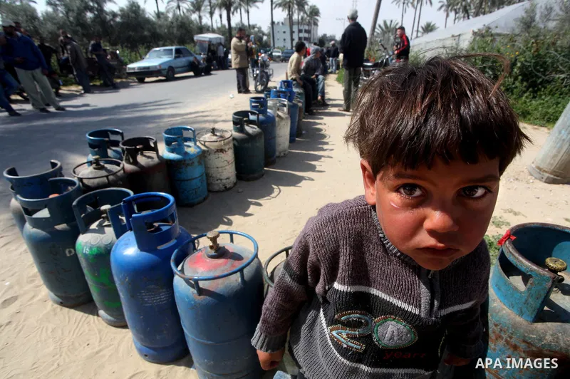 Palestinians wait to fill canisters with cooking gas outside a filling station in Deir al-Balah, in the central Gaza Strip, April 1, 2012. Palestinians in the Gaza Strip are experiencing shortage in gas and fuel. Photo b...