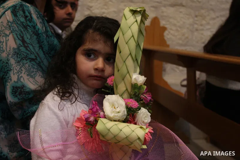 Palestinians Catholic attend a Palm Sunday at a church "Nativity" in Bethlehem in the West Bank in, Sunday, April 1, 2012. Palm Sunday commemorates Jesus Christ's triumphant entry into Jerusalem when his followers laid p...