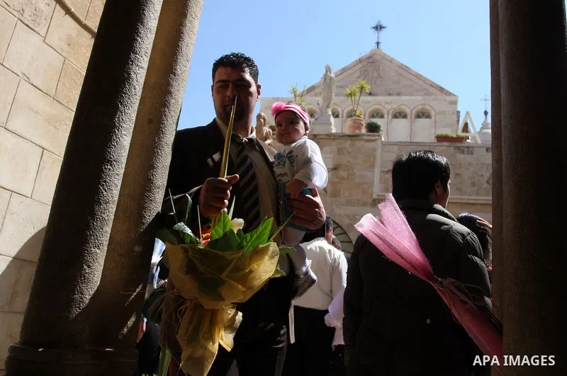 Palestinians Catholic attend a Palm Sunday at a church "Nativity" in Bethlehem in the West Bank in, Sunday, April 1, 2012. Palm Sunday commemorates Jesus Christ's triumphant entry into Jerusalem when his followers laid p...