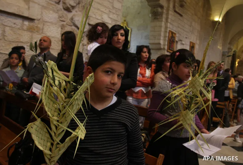 Palestinians Catholic attend a Palm Sunday at a church "Nativity" in Bethlehem in the West Bank in, Sunday, April 1, 2012. Palm Sunday commemorates Jesus Christ's triumphant entry into Jerusalem when his followers laid p...
