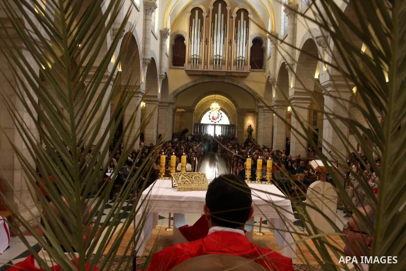 Palestinians Catholic attend a Palm Sunday at a church "Nativity" in Bethlehem in the West Bank in, Sunday, April 1, 2012. Palm Sunday commemorates Jesus Christ's triumphant entry into Jerusalem when his followers laid p...