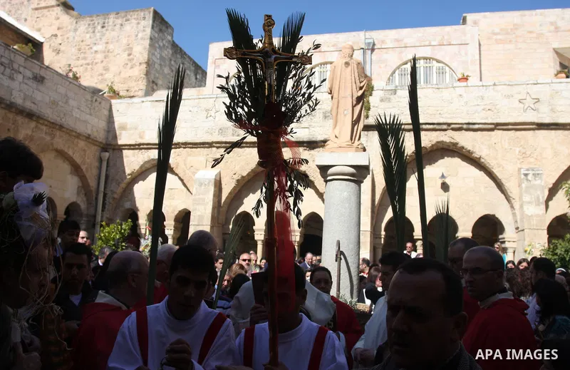 Palestinians Catholic attend a Palm Sunday at a church "Nativity" in Bethlehem in the West Bank in, Sunday, April 1, 2012. Palm Sunday commemorates Jesus Christ's triumphant entry into Jerusalem when his followers laid p...