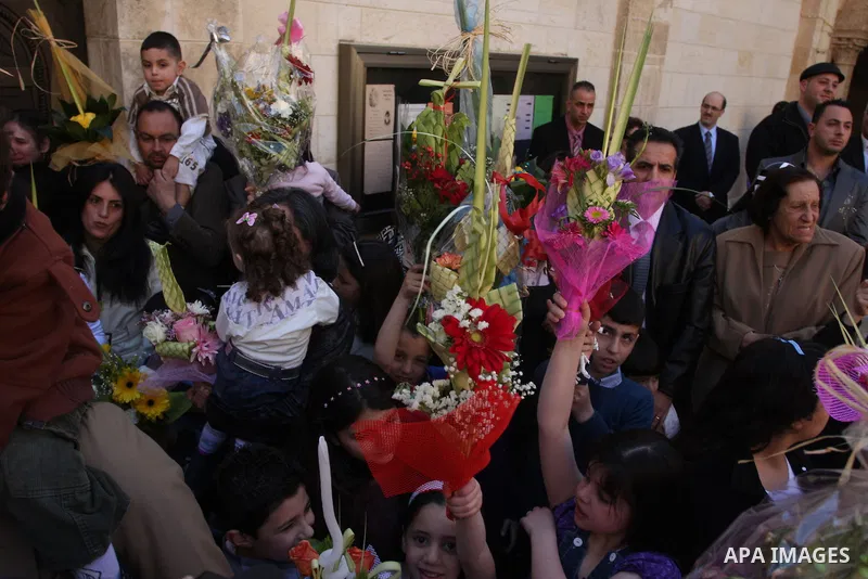 Palestinians Catholic attend a Palm Sunday at a church "Nativity" in Bethlehem in the West Bank in, Sunday, April 1, 2012. Palm Sunday commemorates Jesus Christ's triumphant entry into Jerusalem when his followers laid p...
