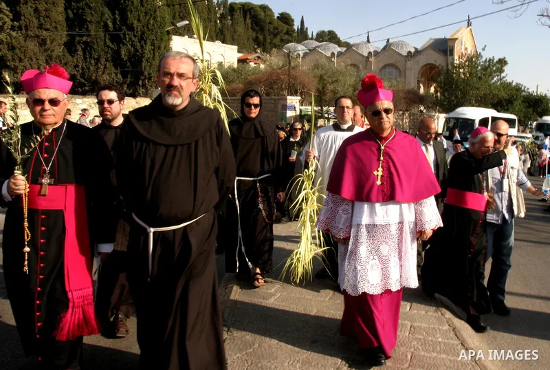 The head of the Roman Catholic Church in the Holy Land, the Latin Patriarch of Jerusalem Fuad Twal, (R) leads the traditional Palm Sunday procession from the Mount of Olives to Jerusalem's old city on April 1, 2012. Phot...
