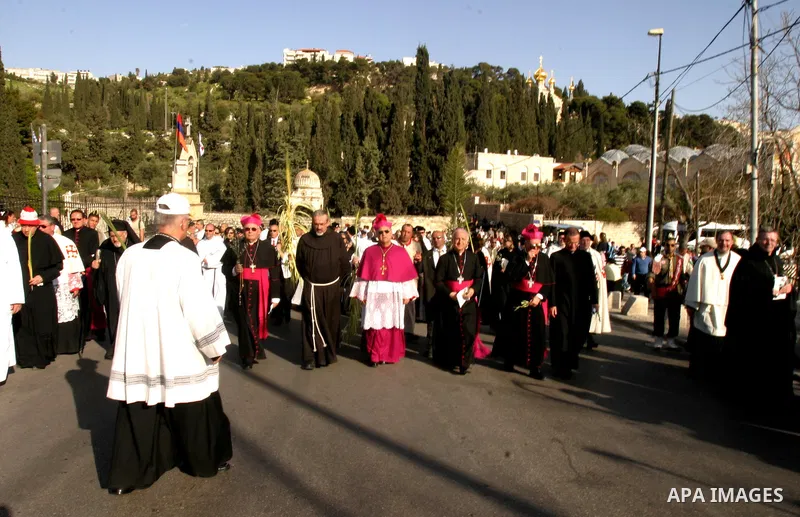 The head of the Roman Catholic Church in the Holy Land, the Latin Patriarch of Jerusalem Fuad Twal, (C) leads the traditional Palm Sunday procession from the Mount of Olives to Jerusalem's old city on April 1, 2012. Phot...