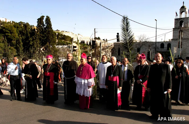 The head of the Roman Catholic Church in the Holy Land, the Latin Patriarch of Jerusalem Fuad Twal, (C) leads the traditional Palm Sunday procession from the Mount of Olives to Jerusalem's old city on April 1, 2012. Phot...