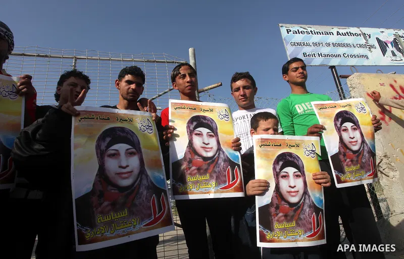 Palestinians hold posters of Hanaa Shalabi, a prisoner who spent 43 days on hunger strike, as they wait to greet her near the Erez border crossing between Israel and the northern Gaza Strip on April 1, 2012. Shalabi, who...