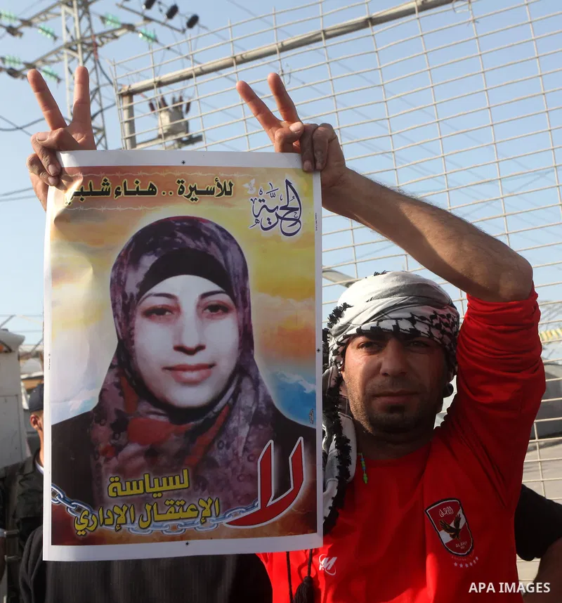 Palestinians hold posters of Hanaa Shalabi, a prisoner who spent 43 days on hunger strike, as they wait to greet her near the Erez border crossing between Israel and the northern Gaza Strip on April 1, 2012. Shalabi, who...