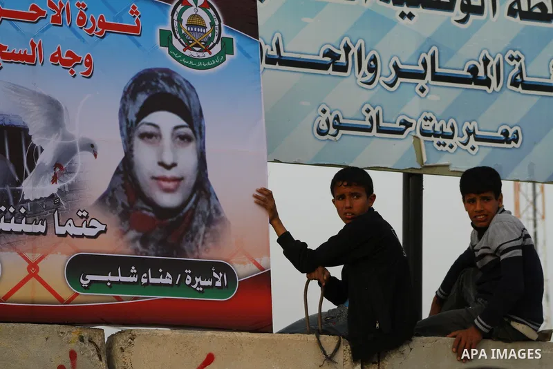 Palestinians hold posters of Hanaa Shalabi, a prisoner who spent 43 days on hunger strike, as they wait to greet her near the Erez border crossing between Israel and the northern Gaza Strip on April 1, 2012. Shalabi, who...