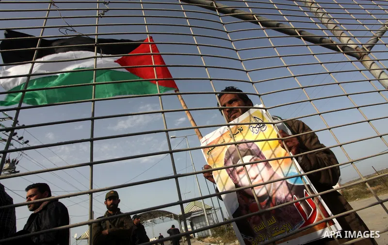 Palestinians hold posters of Hanaa Shalabi, a prisoner who spent 43 days on hunger strike, as they wait to greet her near the Erez border crossing between Israel and the northern Gaza Strip on April 1, 2012. Shalabi, who...