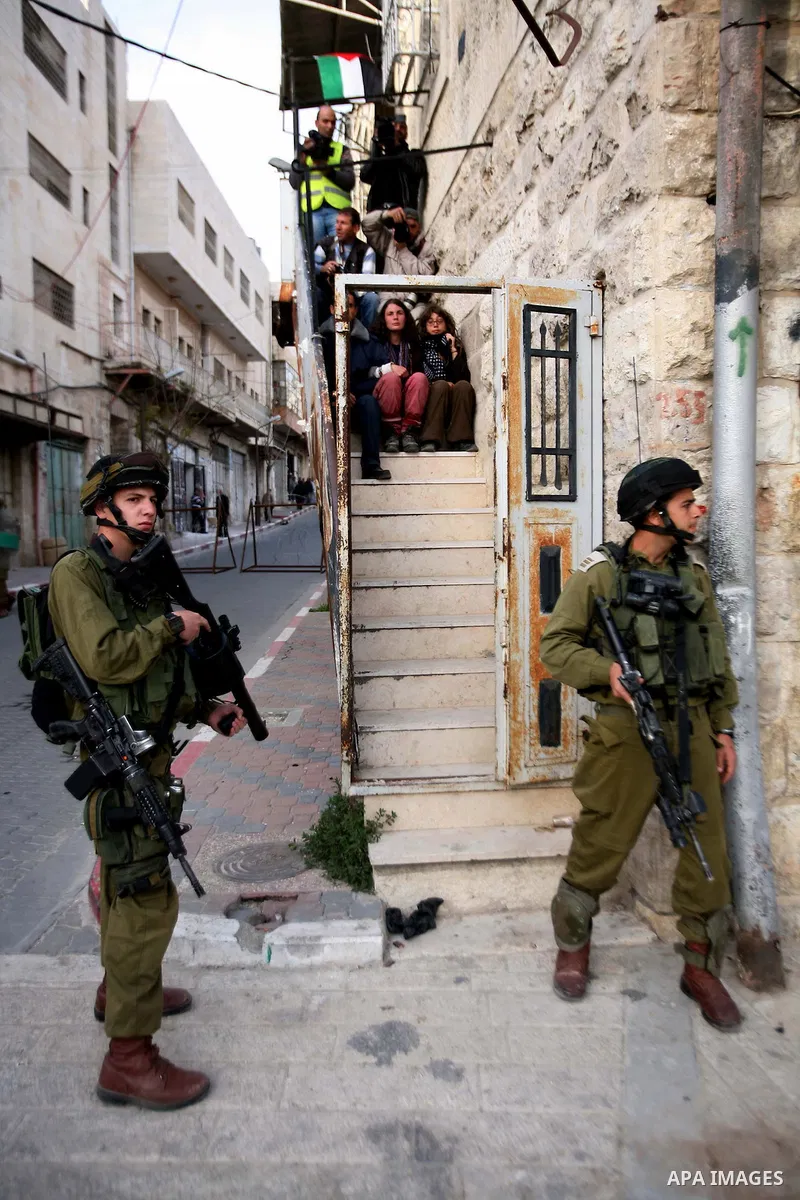 Israeli soldiers enter an abandoned house on April 01, 2012, where Palestinian protesters and foreign activists took refuge and fly Palestinian flags on the building near the Beit Romano area that several hundred Jewish...