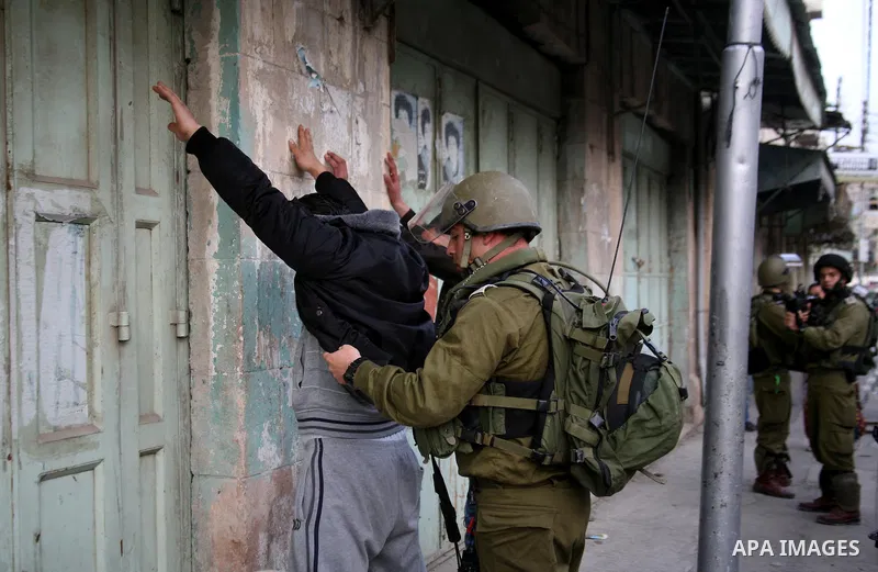 Israeli policemen and soldiers detain Palestinian protesters and foreign activists on April 01, 2012, after they took refuge in an abandoned house and fly a Palestinian flag on the rooftop of the building near the Beit R...