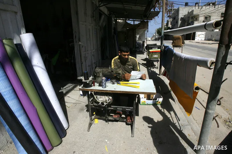 Palestinians read sheets which were thrown by Israeli aeroplane warning the Palestinians from reaching the no-go zone on the border with Israel,in the Rafah on the southern Gaza Strip on April 2,2012. Photo by Eyad Al Ba...